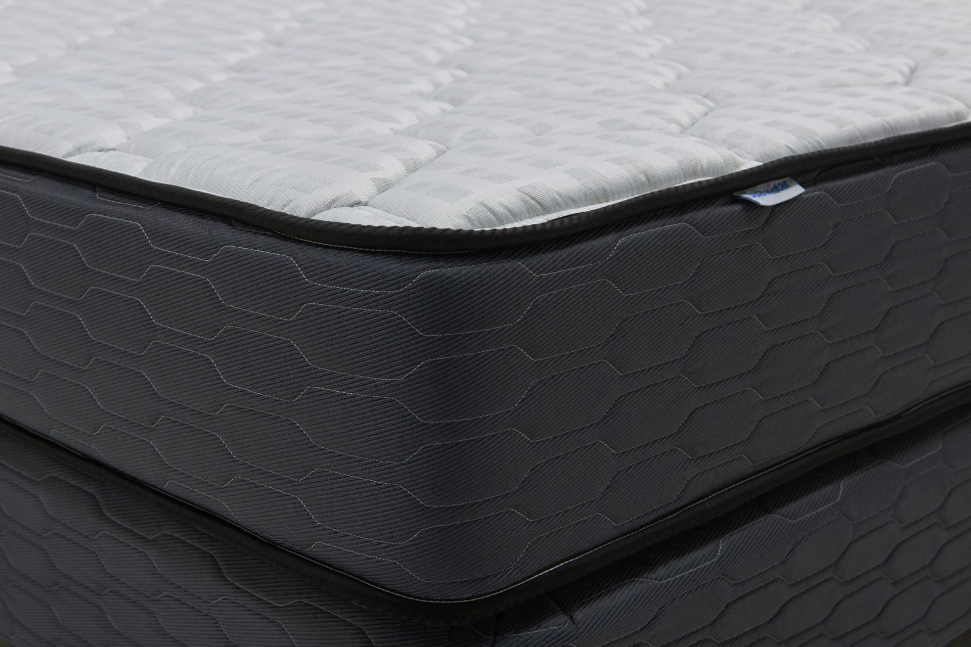 Close-up of a modern mattress with a dark patterned base